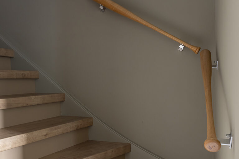 Houten trap met honkbalknuppel leuning